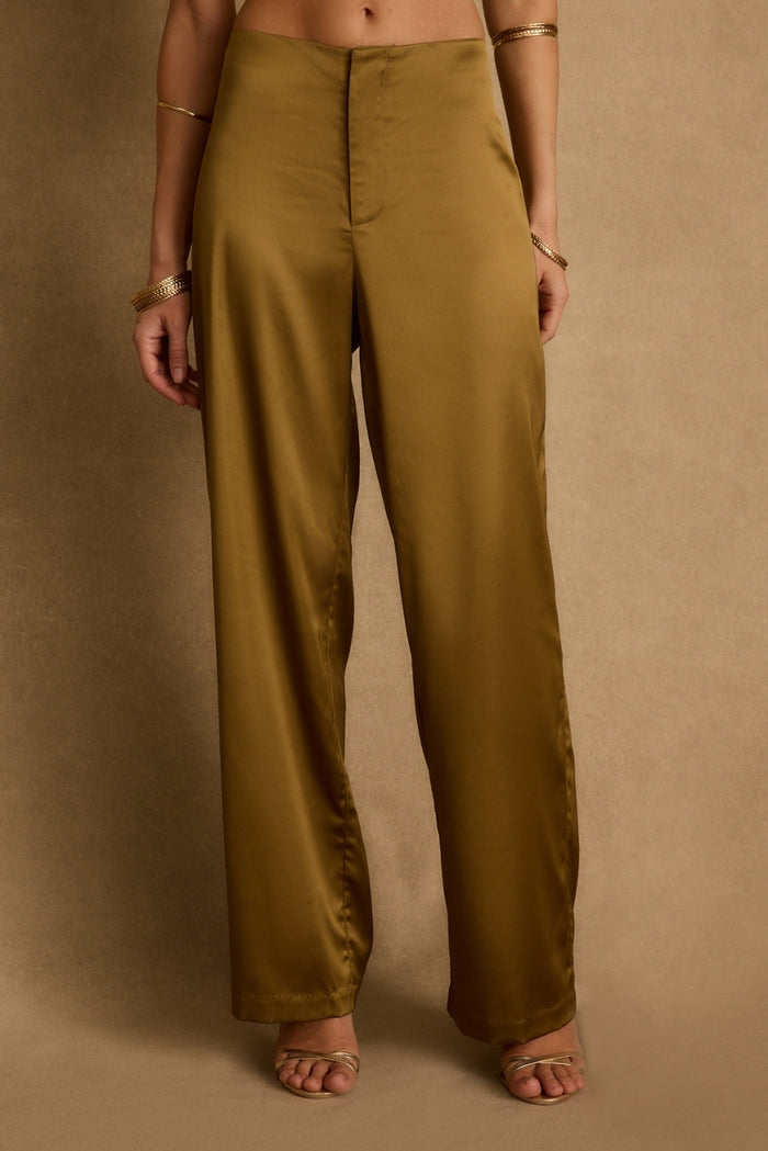 Cropped view of olive satin wide-leg trousers styled with gold bangles and strappy heels.