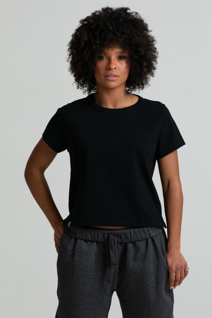 Person wearing a black t-shirt and gray pants against a plain background || black