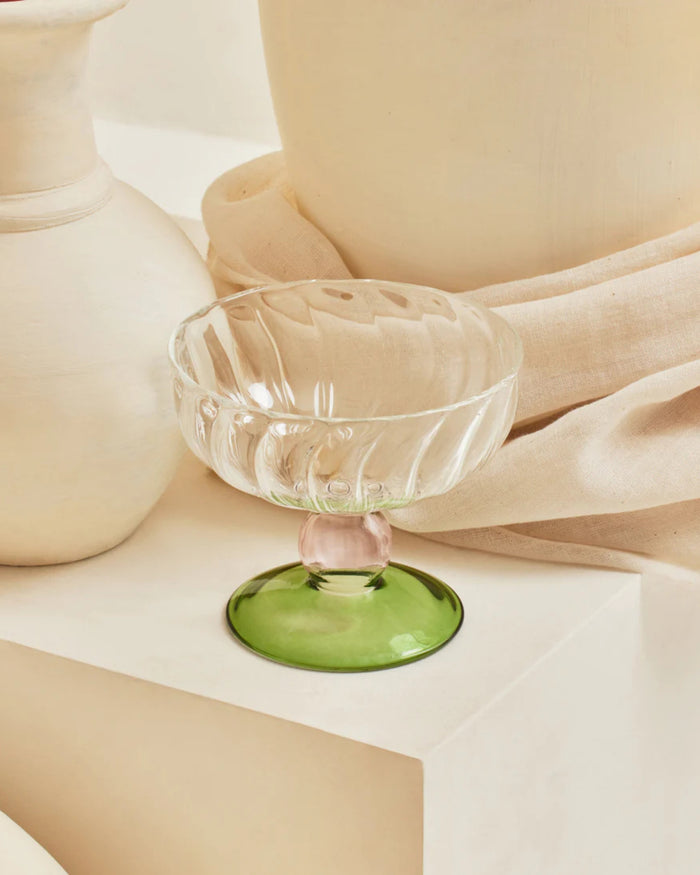 Clear glass dessert bowl with fluted sides on green pedestal base