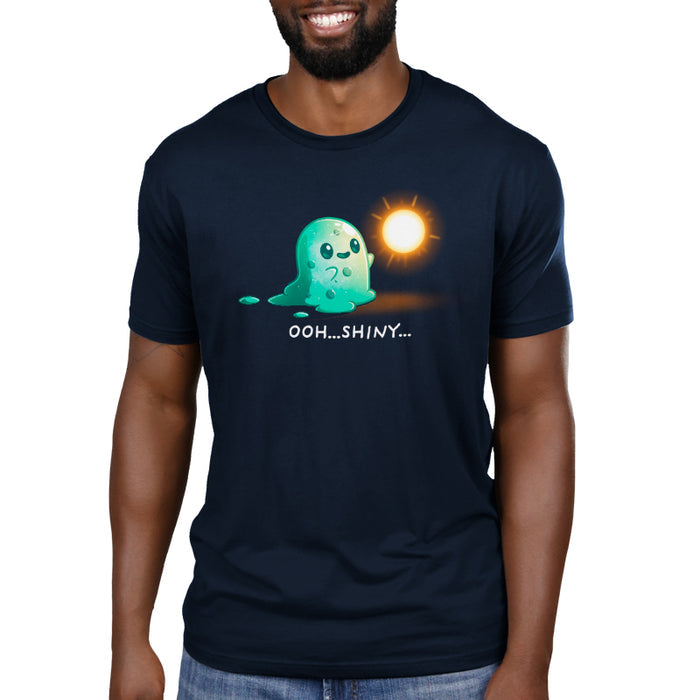 Premium Cotton T-shirt_TeeTurtle Shiny Distraction navy blue t-shirt featuring a slime creature staring in awe at a glowing, golden orb.