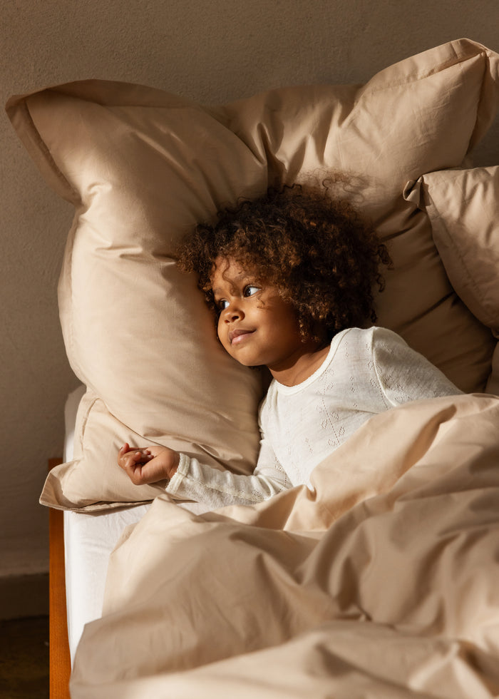 White nightgown on sleeping child, long-sleeve top and long trousers