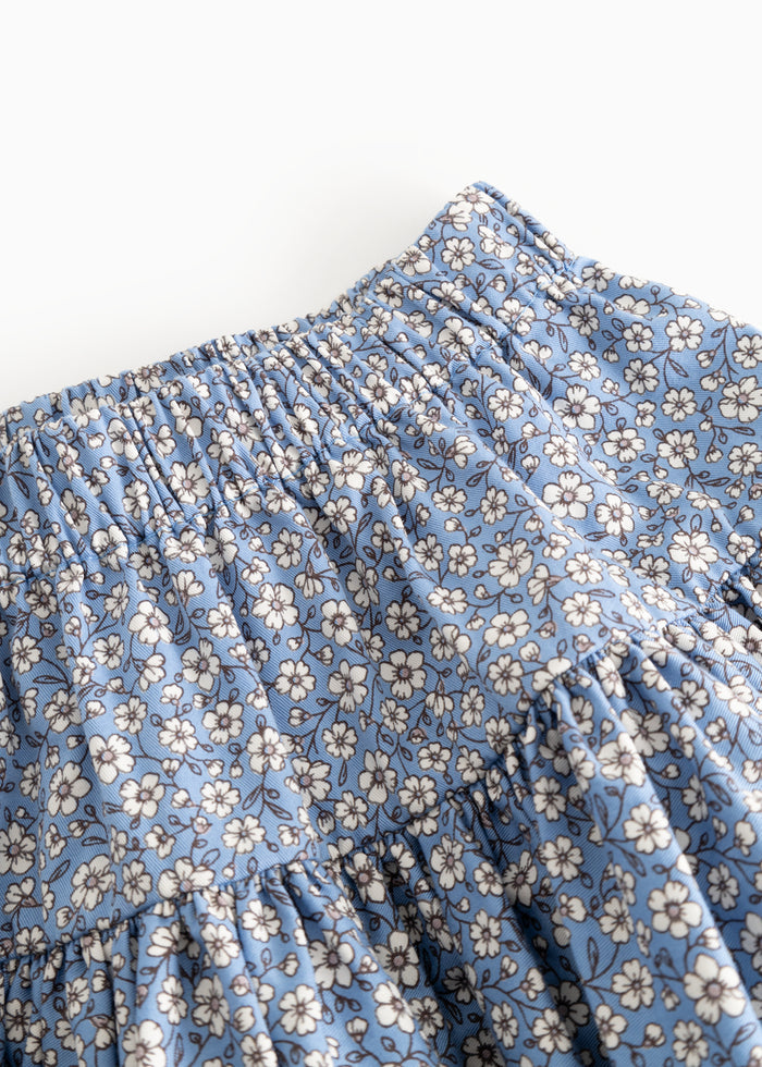 Blue skirt with elastic waistband and pleated fill, small white flowers close together.