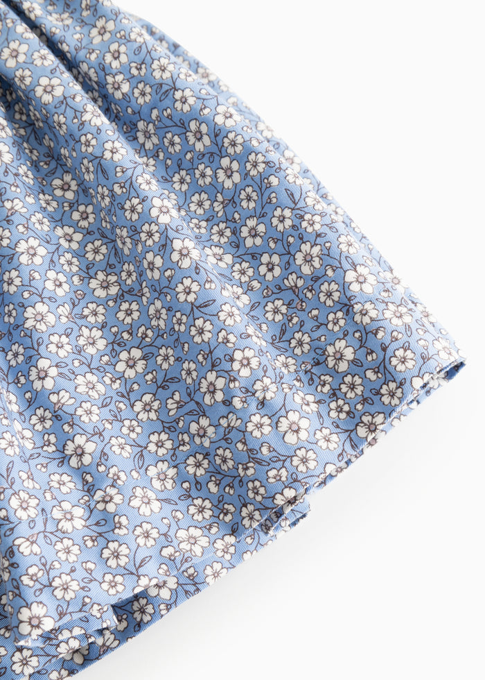 Blue skirt with small white flowers, crinkled edge and lightweight fabric.