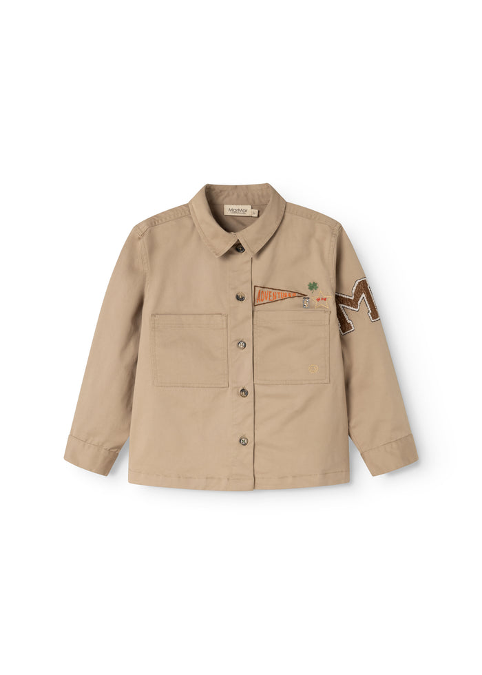 Beige children's jacket with reversible collar, buttons, and chest pockets.