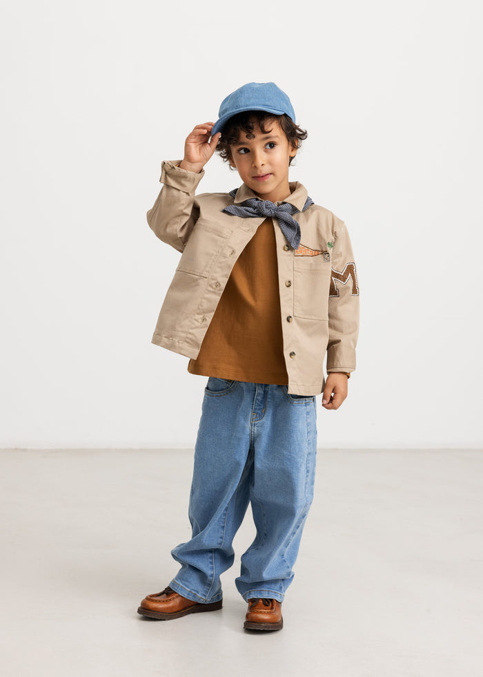 Kids jacket in mud color with button closure and chest pockets, shirt collar.