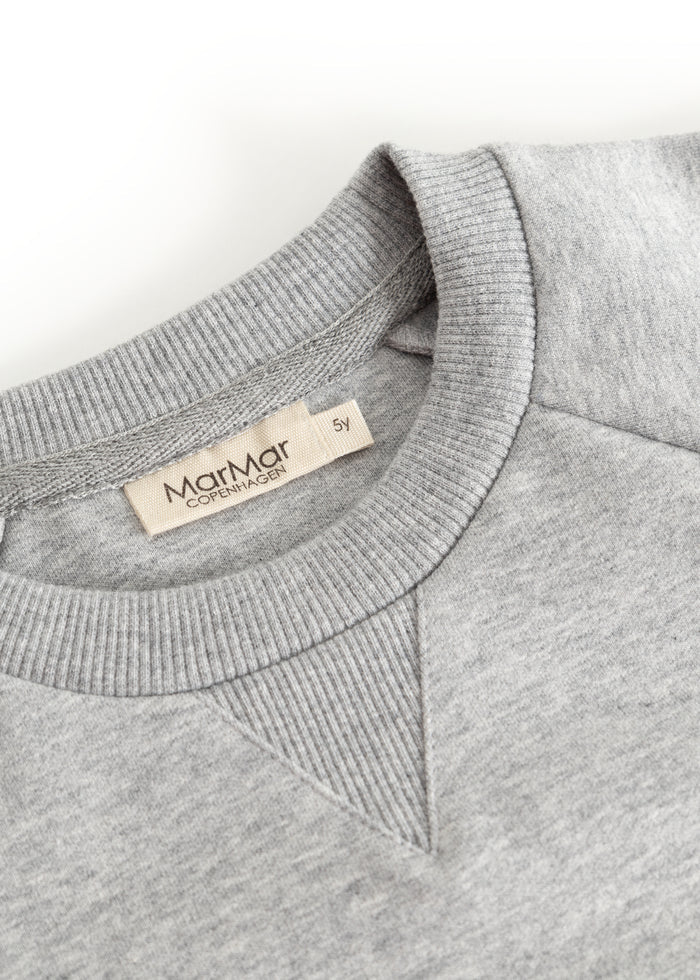 Gray sweatshirt collar with ribbing and beige brand label on the inside